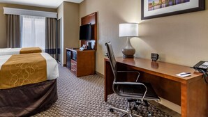 A hotel room with two beds, a desk with a lamp, a TV, and a cityscape painting on the wall. - Comfort Suites Near Texas A&M University - Corpus Christi (Corpus Christi)