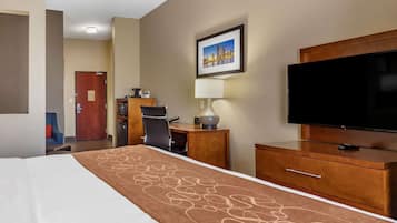 Une chambre d’hôtel équipée d’un lit, d’un bureau, d’une chaise, d’une télévision et d’une lampe.