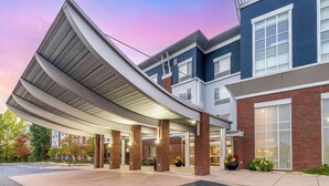 A modern building with a curved roof entrance, brick facade, and large windows. - Cambria Hotel Minneapolis Maple Grove (Maple Grove)