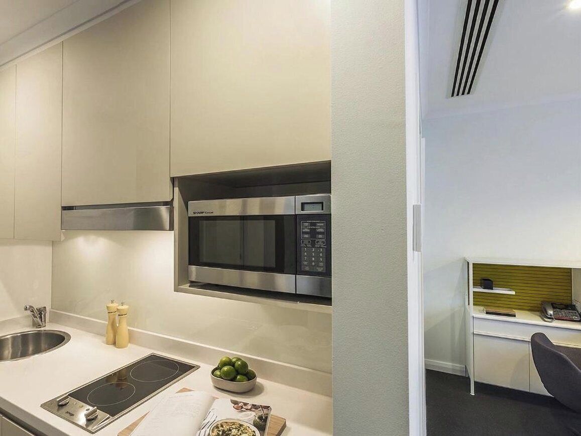 A modern kitchen with a built-in microwave, a stove, and a sink.