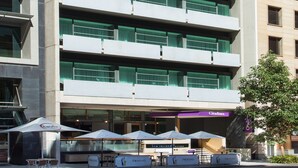 Un hotel de varios pisos con terraza y un restaurante visible llamado "Le Terroir Lounge".