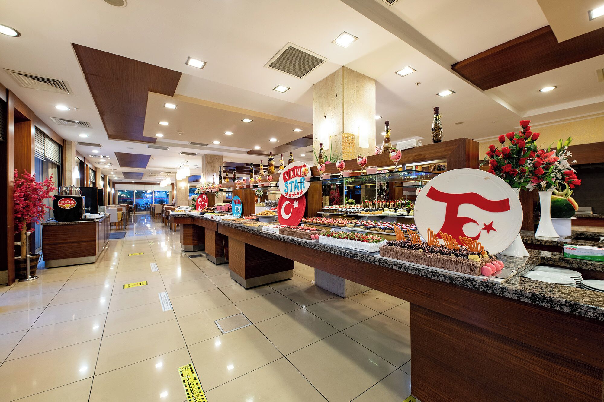 Zona de bufé con varias estaciones de comida, una máquina de café y un letrero que indica 'Viking Star'.