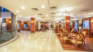A spacious lobby with a marble floor, wooden furniture, and a glass railing. - Hotel Viking Star (Kemer)