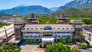 A hotel with a central courtyard, multiple floors, and a mountain backdrop. - Hotel Viking Star (Kemer)