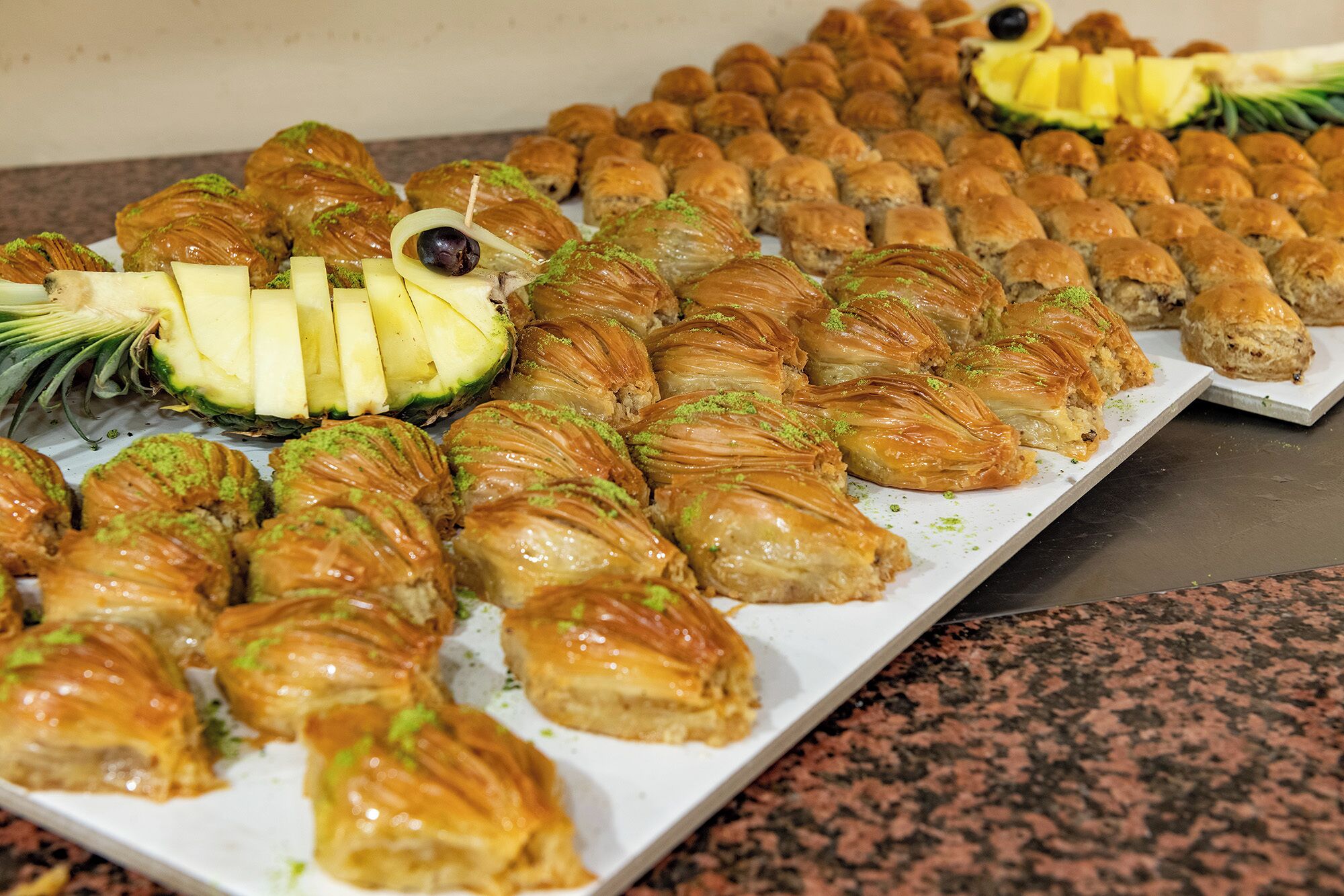 Una variedad de pasteles, incluyendo baklava y otros postres, dispuestos en una bandeja.