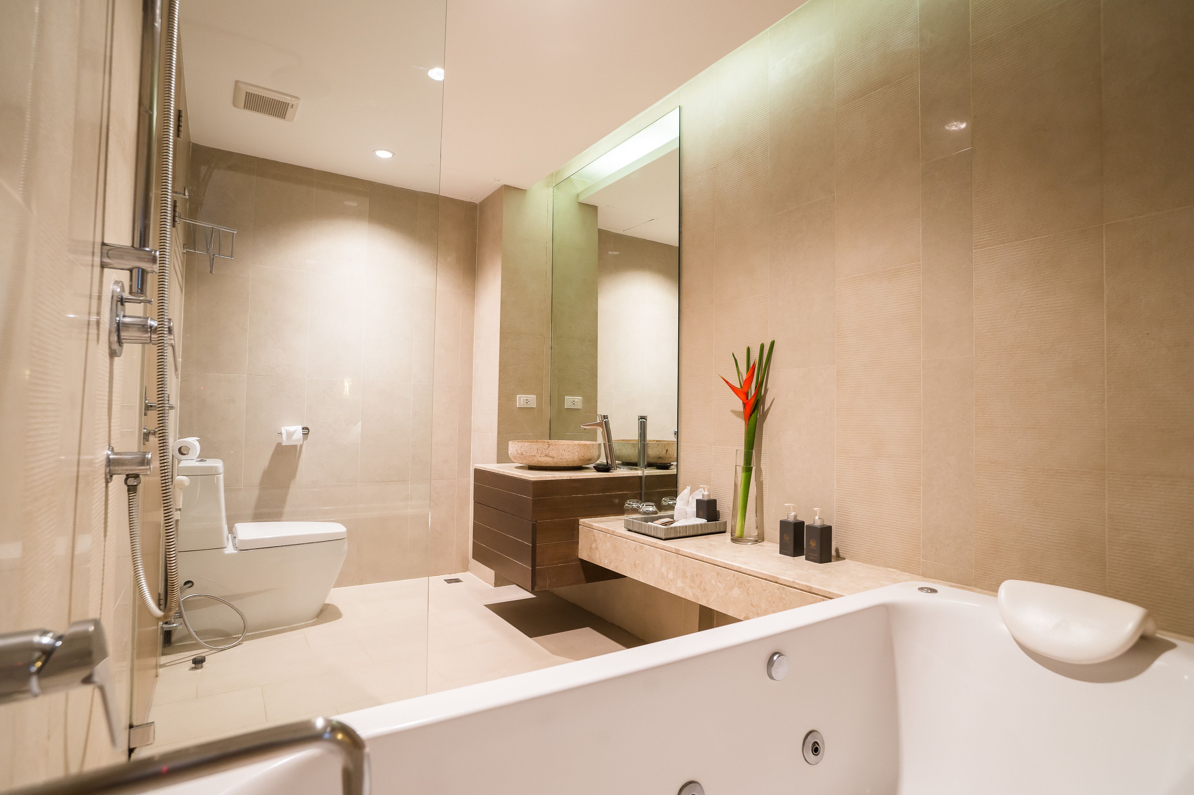 Un baño moderno con ducha envuelta en vidrio, inodoro, lavabo con tocador y bañera.