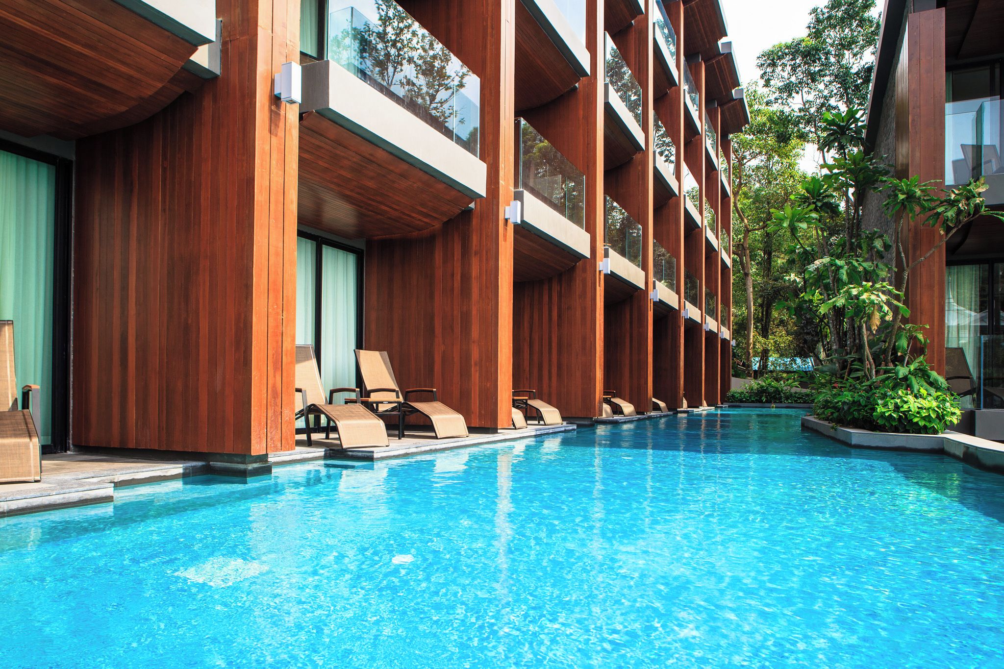 A swimming pool with lounge chairs and a wooden building structure.