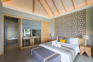 Una habitación de hotel moderna con una cama grande, un escritorio y un baño con bañera.