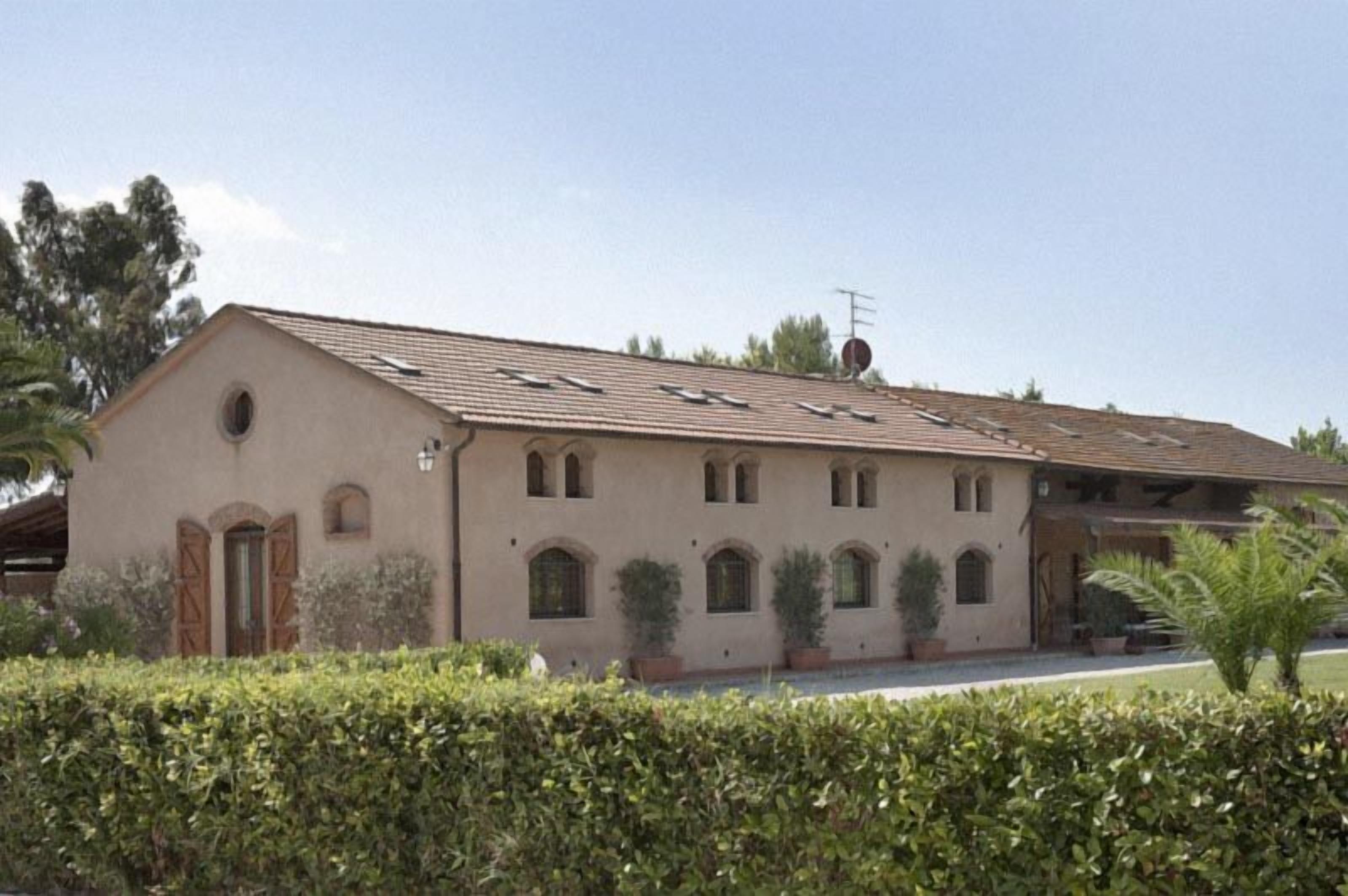 A two-story building with a flat roof, multiple windows, and a small satellite dish.