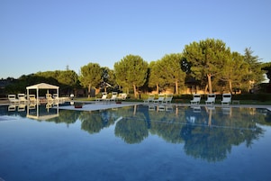Una piscina al aire libre de temporada, sombrillas