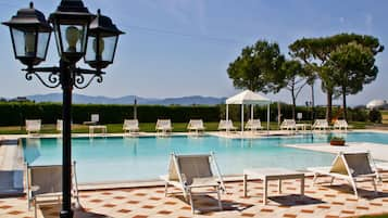 Una piscina al aire libre de temporada, sombrillas