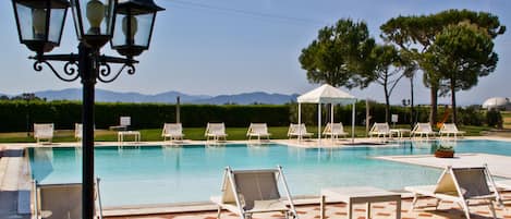 Una piscina al aire libre de temporada, sombrillas