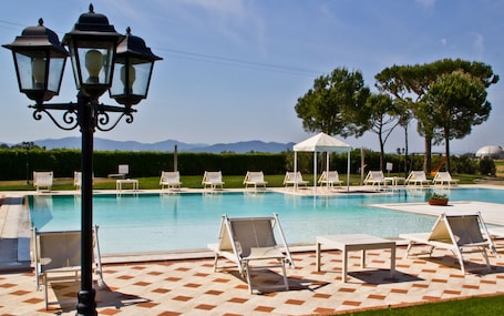 Una piscina al aire libre de temporada, sombrillas
