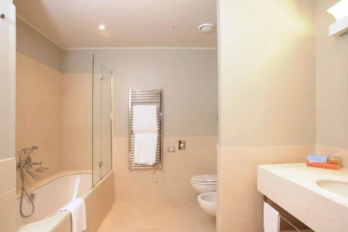 Deep soaking tub, rainfall showerhead, eco-friendly toiletries