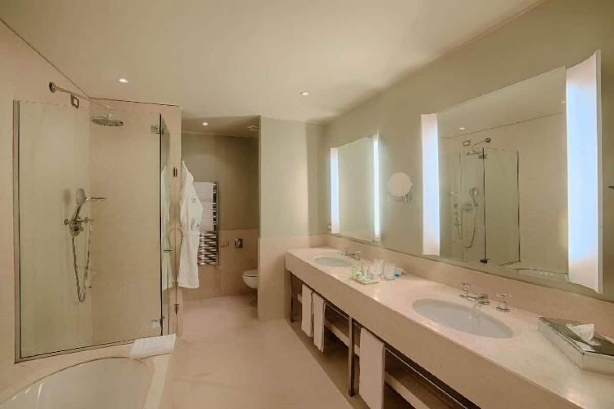Deep soaking tub, rainfall showerhead, eco-friendly toiletries