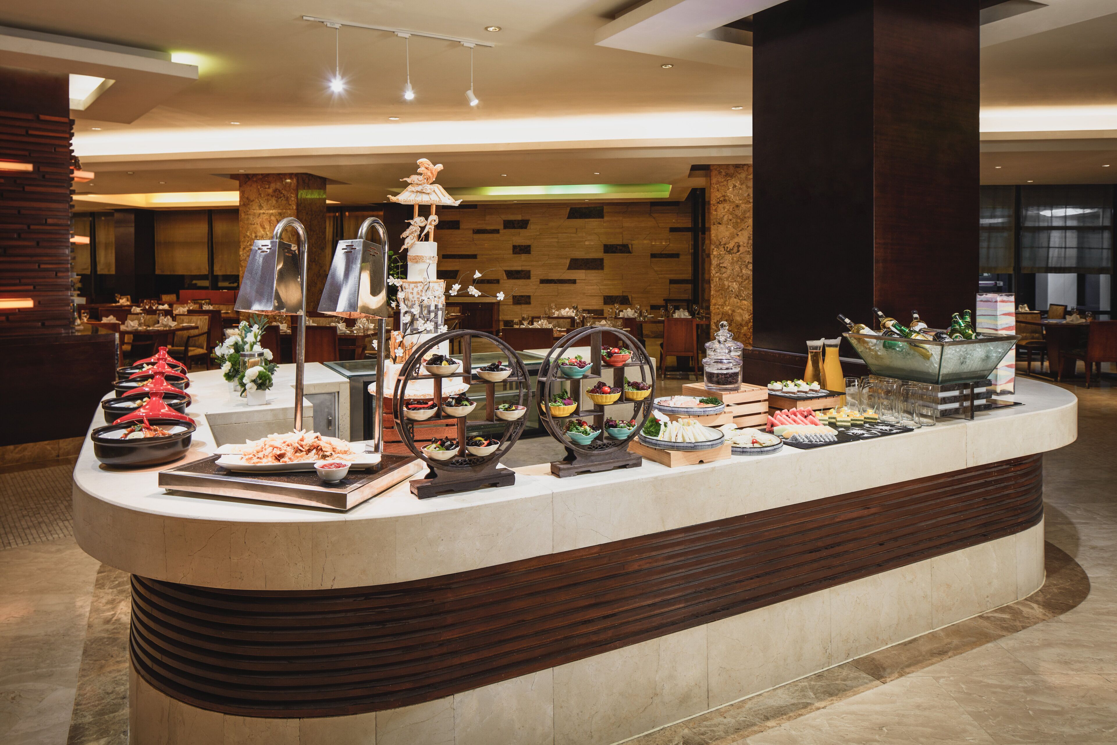 A buffet setup with various food items and decorative elements in a well-lit indoor space.