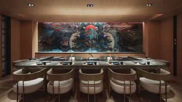 A modern kitchen with a large island, bar stools, and a vibrant mural on the wall.
