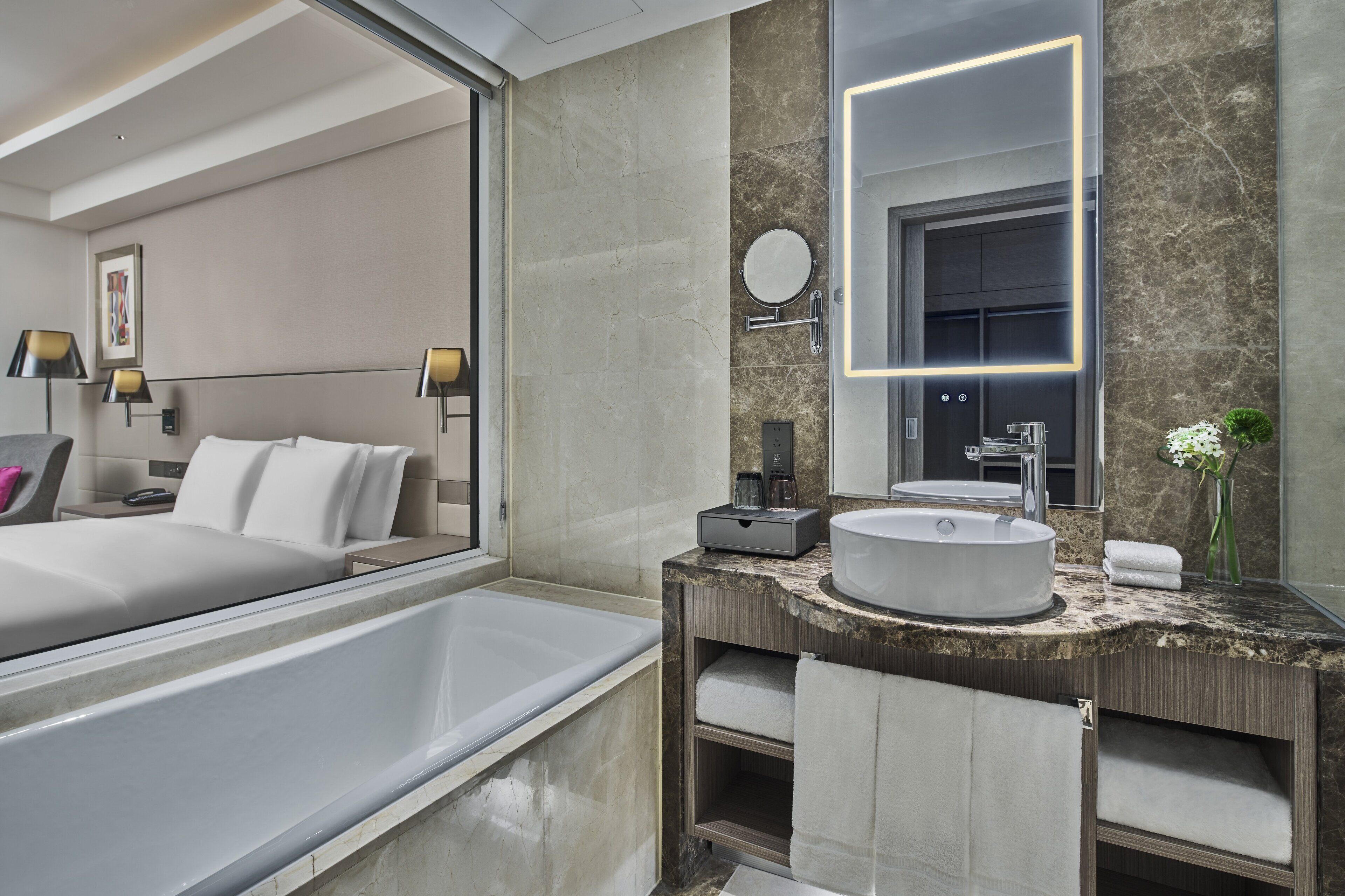 A modern bathroom with a bathtub, a sink, and a mirror.