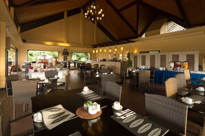 A spacious dining area with high ceilings and natural light, featuring wicker furniture and a central bar area. - Alta Vista De Boracay (Boracay Island)