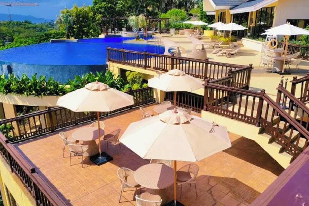 Una terraza con mobiliario exterior, piscina y vistas al paisaje.