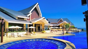 A resort with a large infinity pool, lounge chairs, and umbrellas. - Alta Vista De Boracay (Boracay Island)