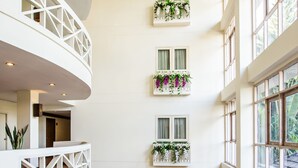 Un vaste atrium doté d’un haut plafond, de nombreux balcons et de grandes fenêtres.