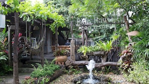 A rustic garden with a wooden structure, a small waterfall, and lush greenery. - Eco Resort Chiang Mai (Chiang Mai)