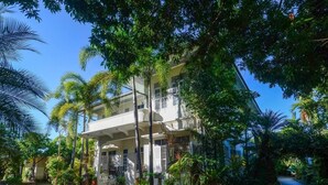 A two-story building with a balcony, surrounded by lush tropical vegetation. - Eco Resort Chiang Mai (Chiang Mai)