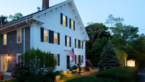 A two-story white house with dark shutters, an American flag, and a sign indicating 'The Inn at Varnum Hill'. - The Inn at Yarmouth Port (Yarmouth Port)