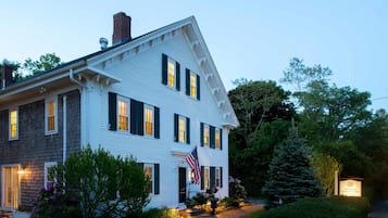 Set amidst lush gardens, this charming building features a prominent entrance with a flag and a signboard.