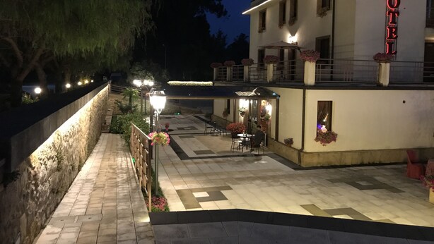 A hotel with a well-lit outdoor area, including a paved walkway and seating arrangements. - Hotel Al Ritrovo (Piazza Armerina)