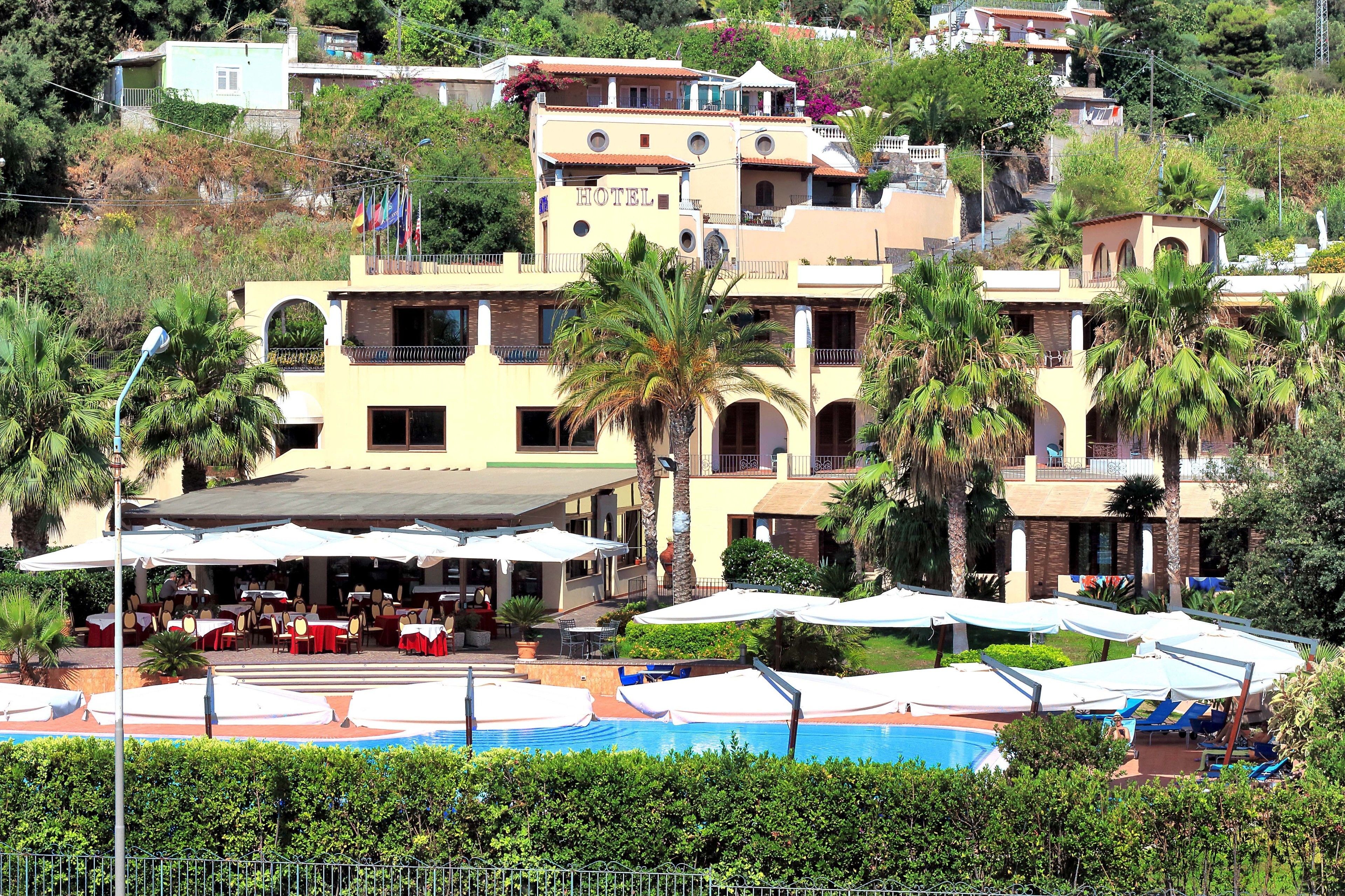 Un hôtel doté de nombreux balcons, d’une piscine et d’espaces de détente en plein air.