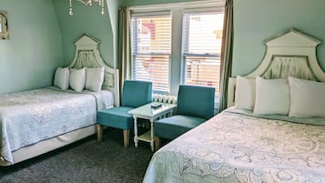 A room with two beds, a small table, and a chair.