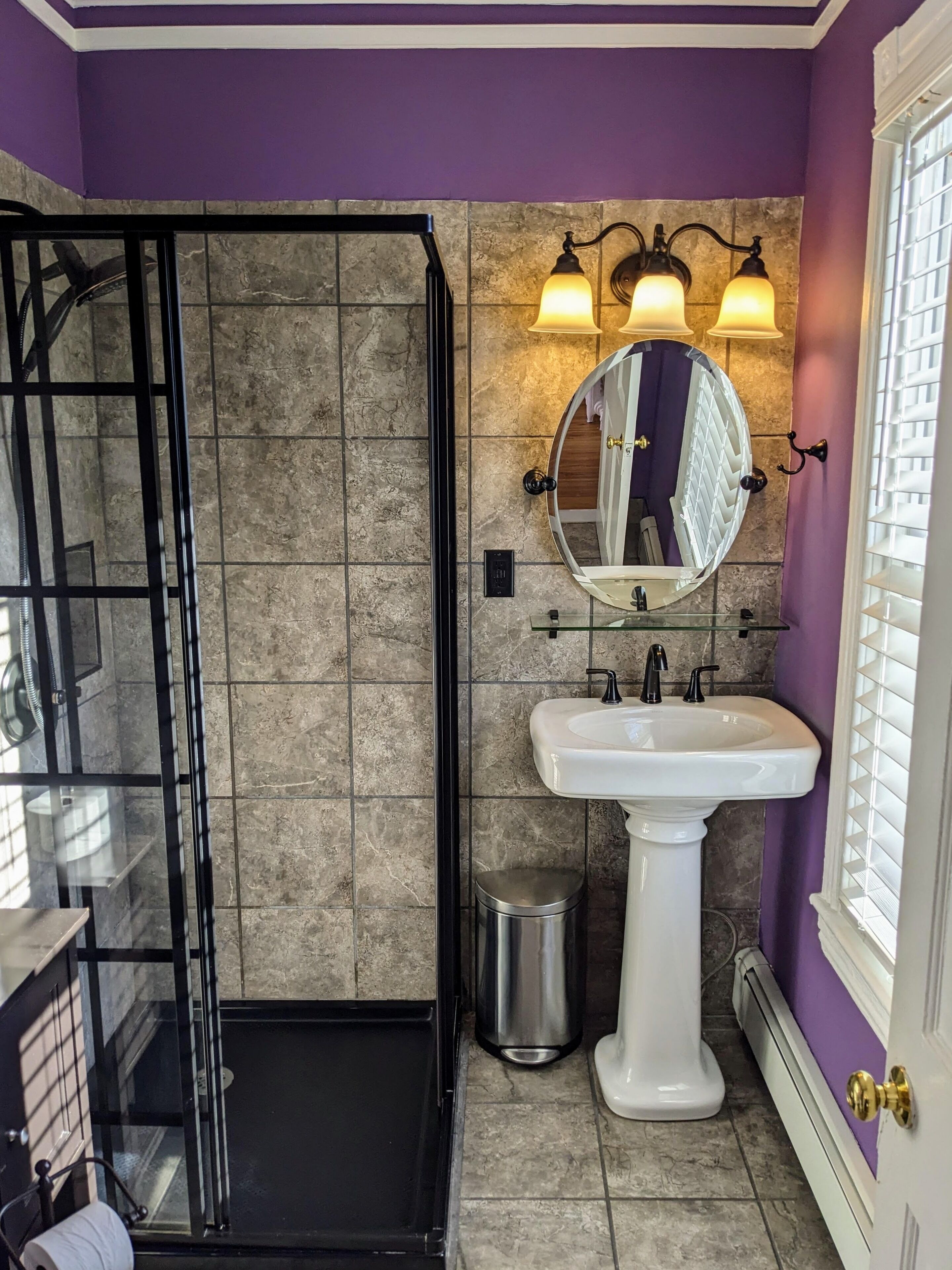 A bathroom with a shower, a sink, and a mirror.