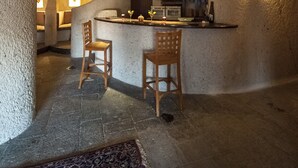 A cozy interior with a bar area, wooden chairs, and a patterned rug. - Uchisar Kaya Hotel - Special Class (Nevsehir)