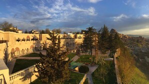 A historic building with arched windows and a courtyard. - Uchisar Kaya Hotel - Special Class (Nevsehir)