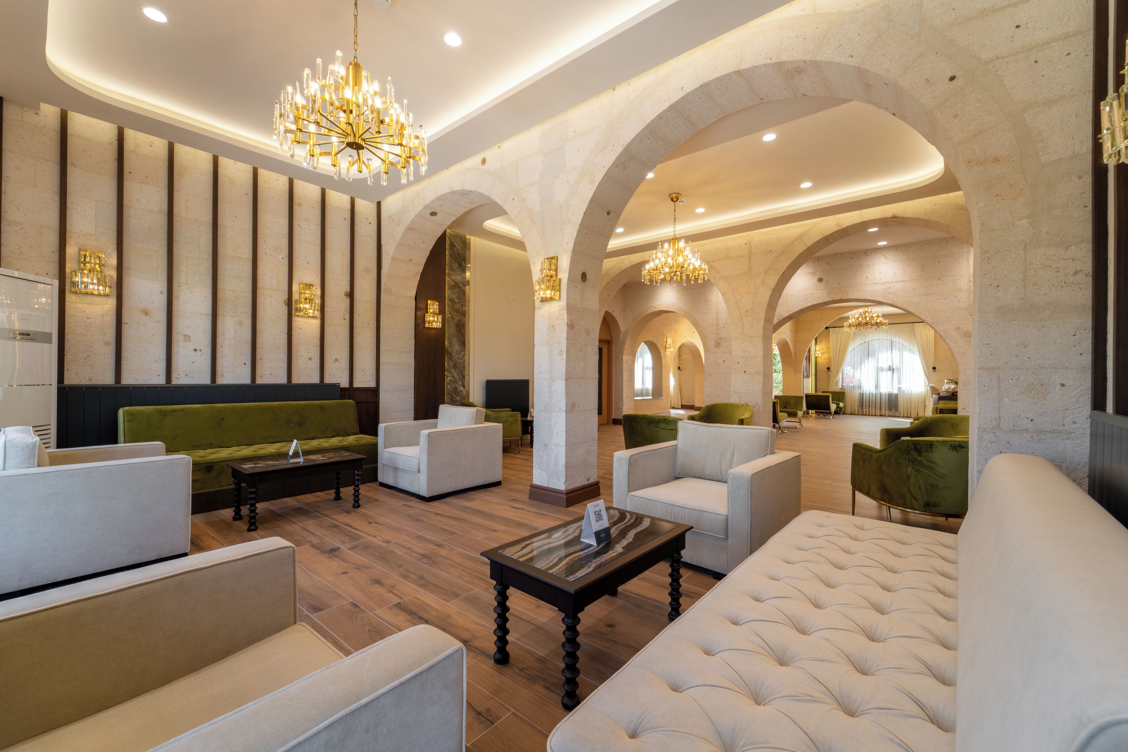 Un hall espacioso con techos altos, arcos y luminarias modernas.