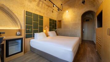 Une chambre moderne avec un grand lit, un bureau et un téléviseur intégré.