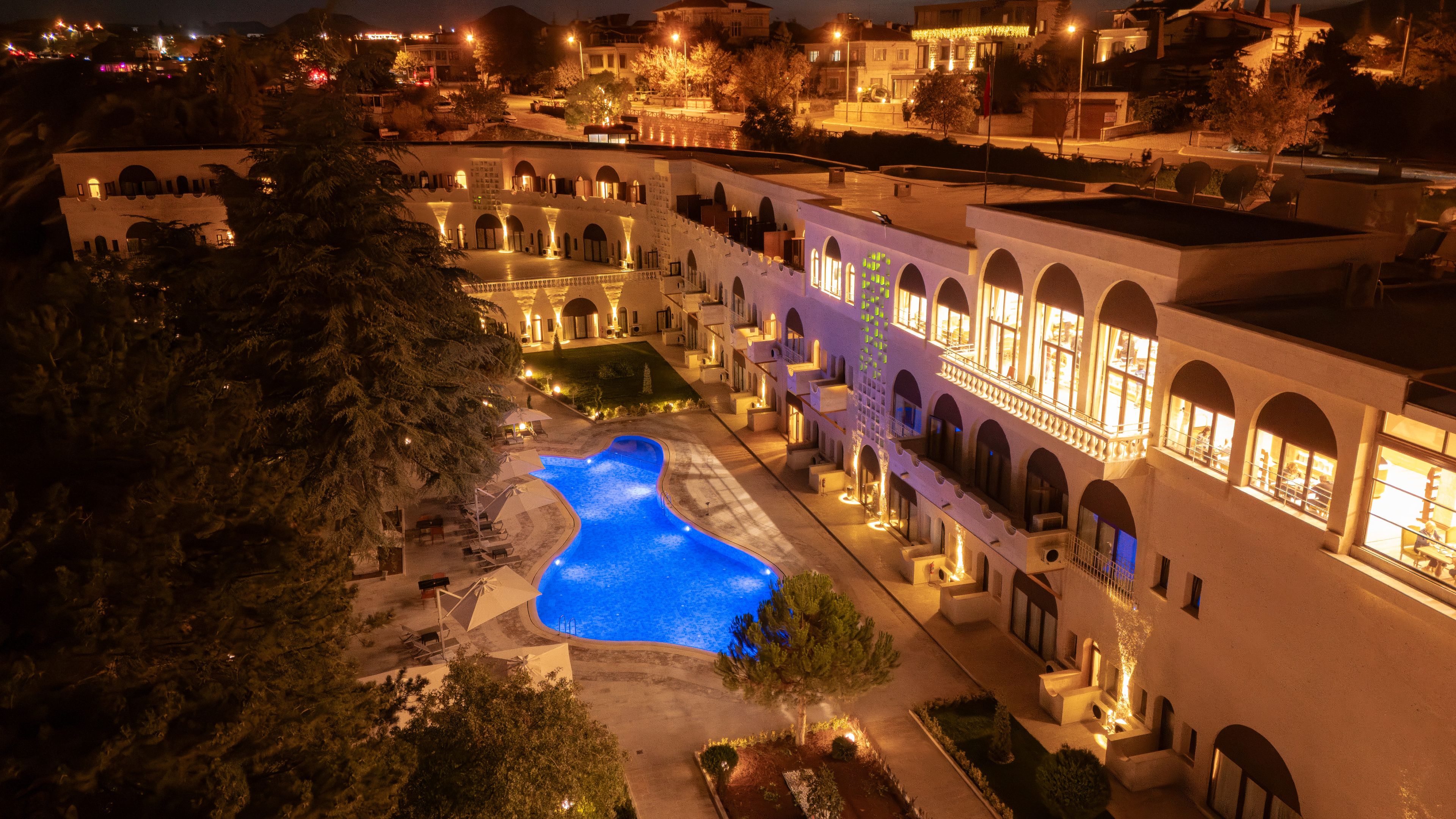 Hotel amb piscina, diversos balcons i façana ben il·luminada.