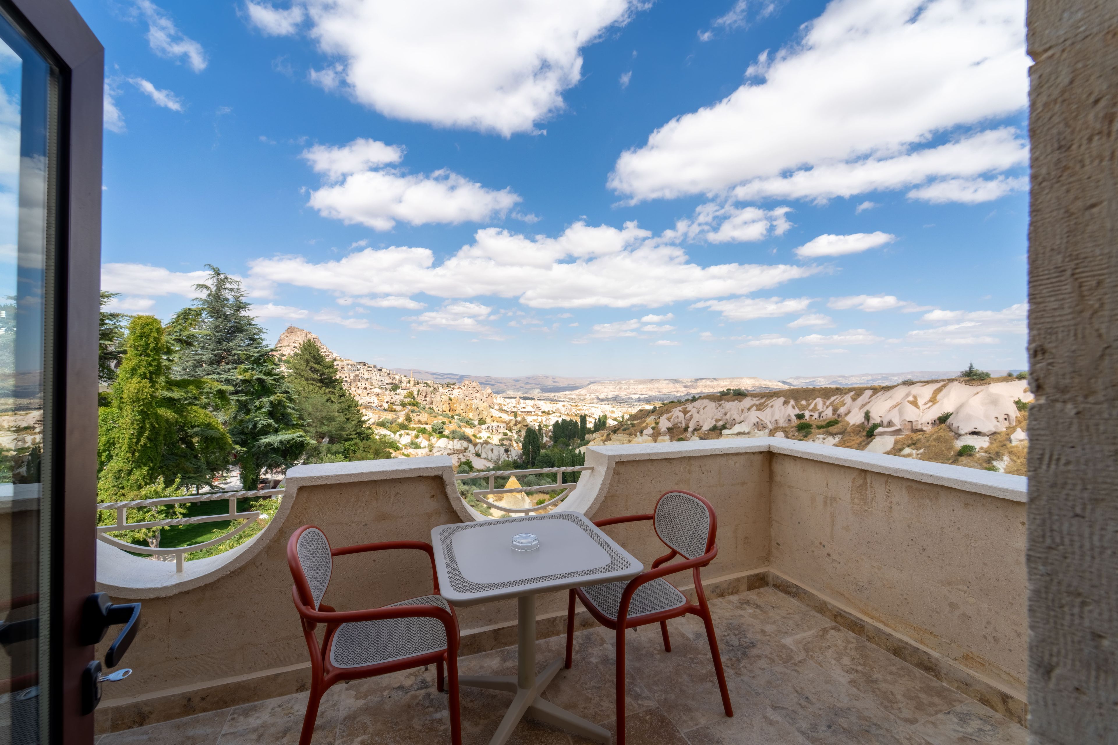 Un balcon avec une table et des chaises donnant sur un paysage pittoresque.