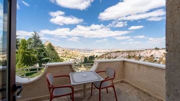 Un balcon avec une table et des chaises donnant sur un paysage pittoresque.