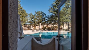 A pool area with a clear view of the surrounding landscape, including trees and a distant rocky outcrop.