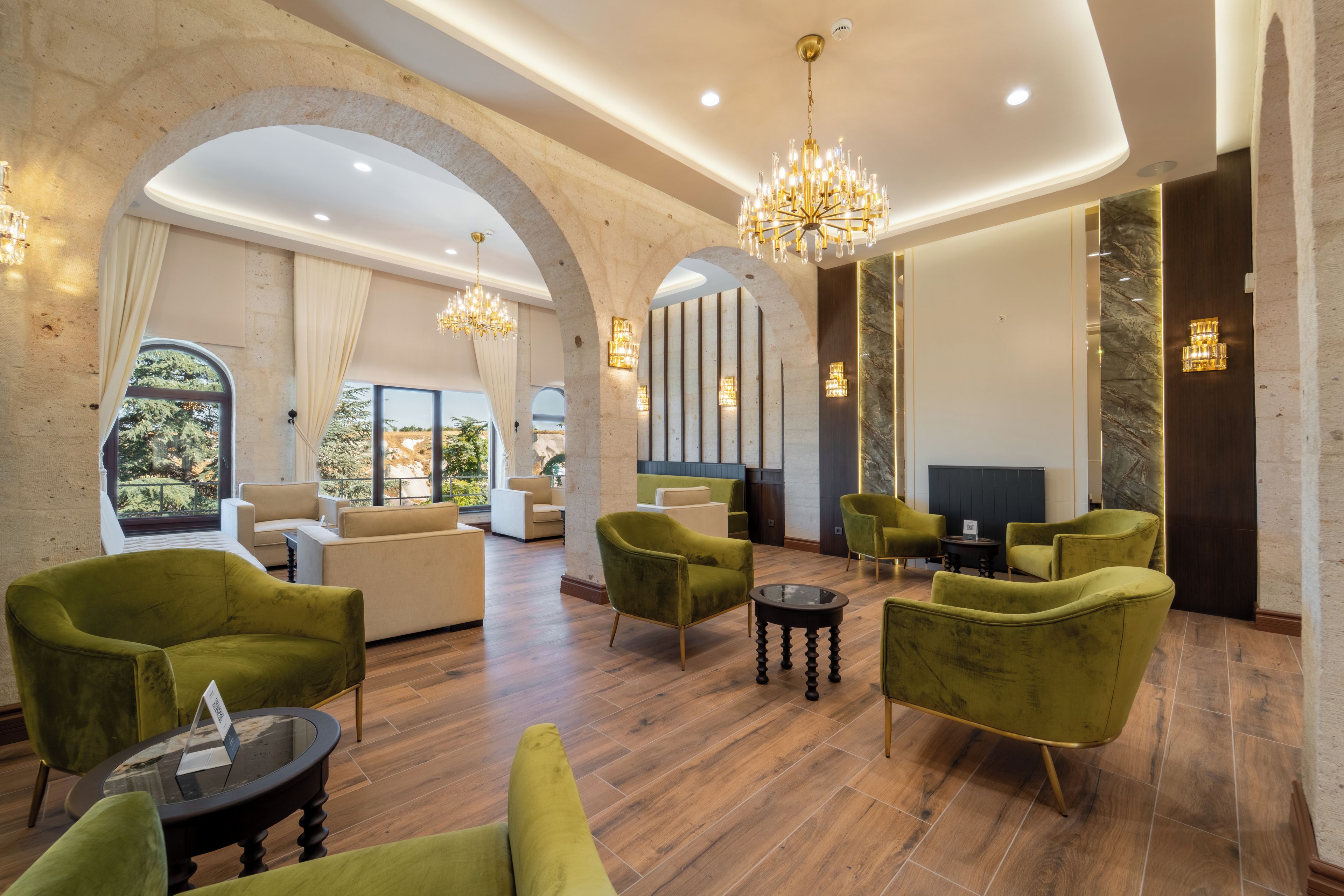 A spacious lobby with high ceilings, arched alcoves, and a grand chandelier.