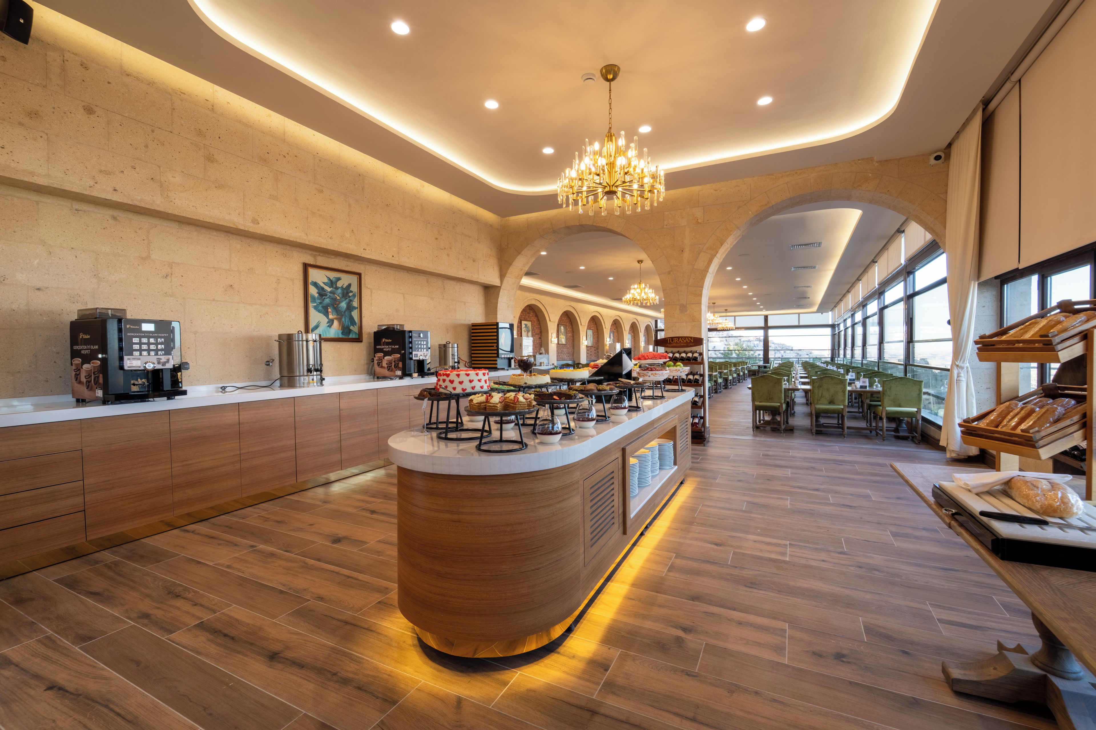 A modern cafe with a central counter, seating area, and large windows.