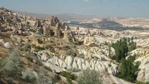 A rugged landscape with a village nestled among rocky formations. - Uchisar Kaya Hotel - Special Class (Nevsehir)