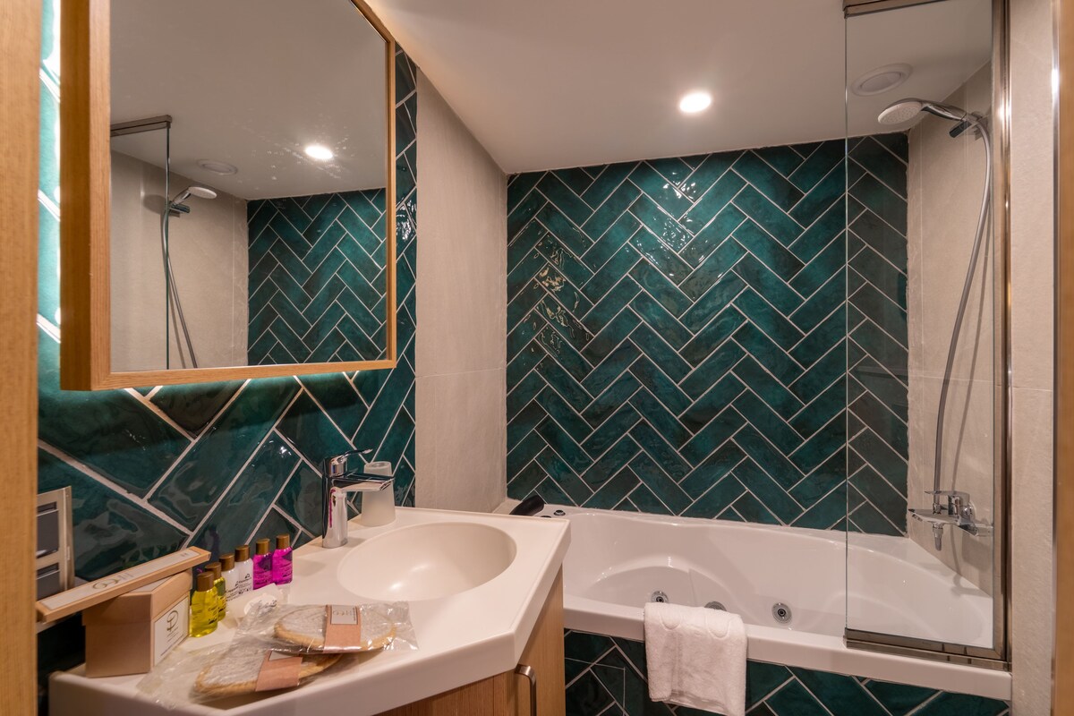Deluxe Room with Balcony and Jacuzzi | Bathroom | Bathtub, deep soaking tub, free toiletries, hair dryer