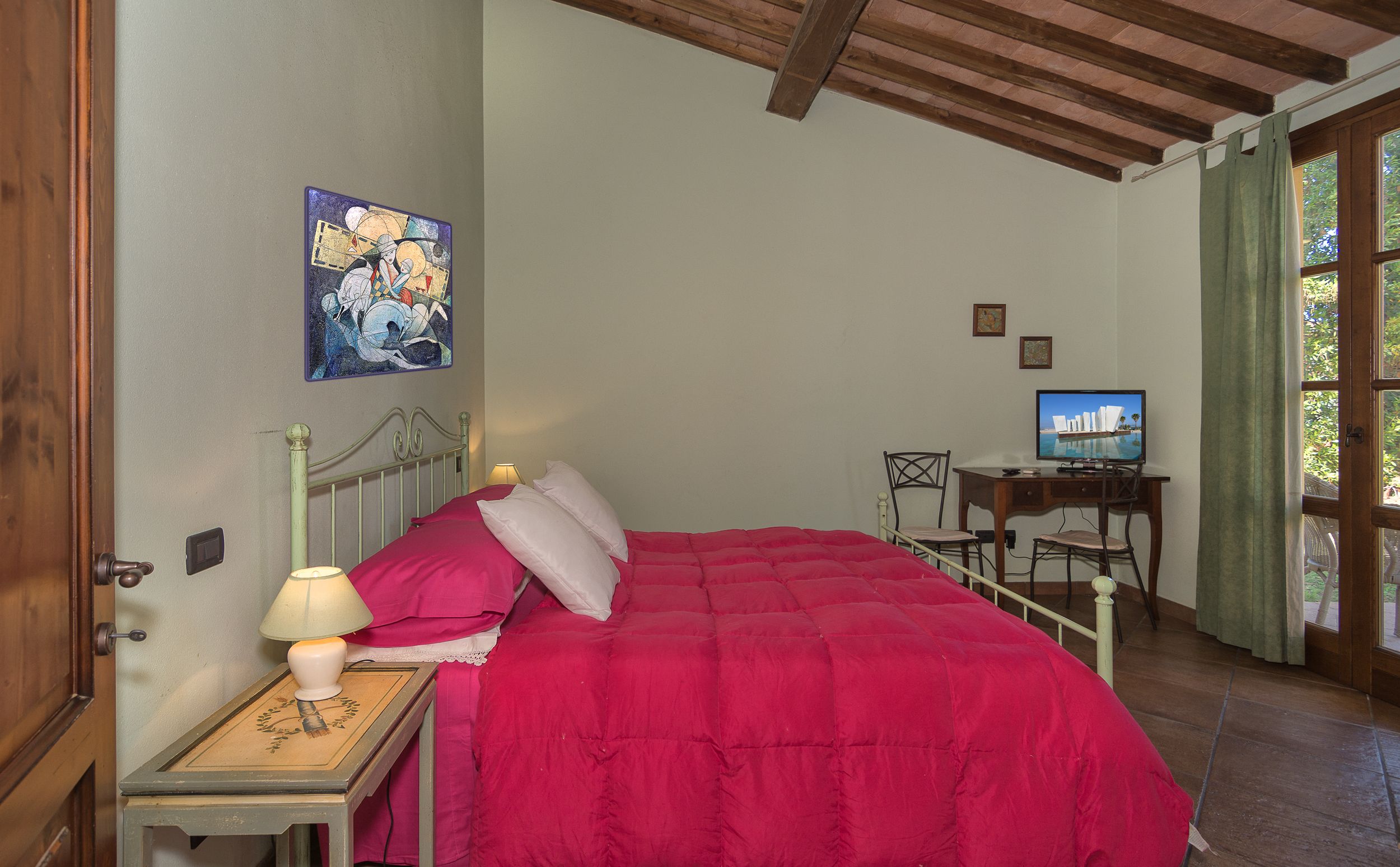 Une chambre à coucher avec un lit, un bureau avec un ordinateur, une lampe et un tableau au mur.