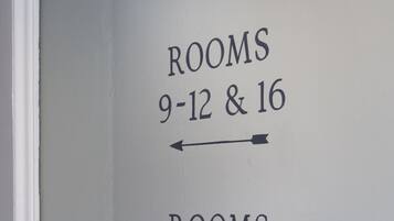 A wall with directional arrows pointing to room numbers 9-12 & 16 and 13-15.