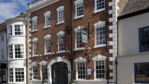 A traditional brick building with a white facade, multiple windows, and a prominent entrance. - The George Townhouse (Shipston on Stour)