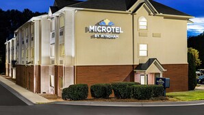 Een Microtel by Wyndham hotel met een gevel van baksteen, meerdere ramen en een verzorgd gazon.